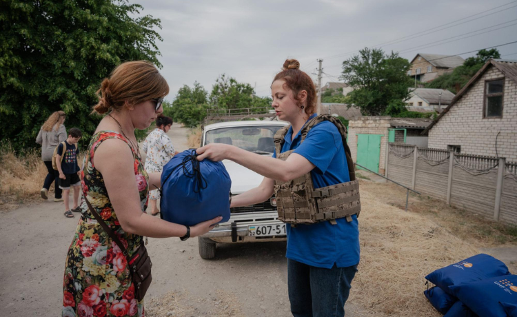 A coordinator and psychologist with a relief centre for survivors of gender-based violence in Kherson, Ukraine, distributes UNFPA dignity kits tailored to meet the immediate sexual and reproductive health needs of women and girls. © UNFPA Ukraine/Danil Pavlov